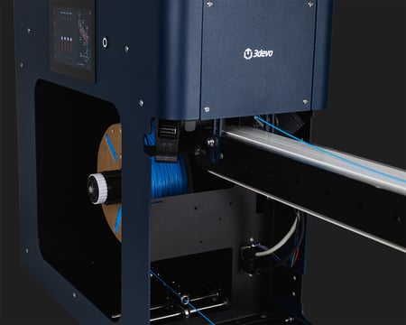 Close-up of the FMX10's spool bay and touchscreen, with filament extruded from the nozzle, placed onto the conveyor belt, and winded on the spool.