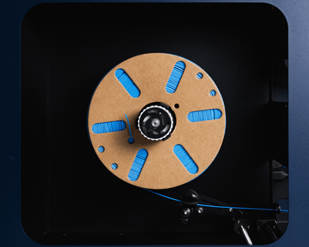 Close-up of the FMX10's PrecisionLock winder assembly with a spool of blue filament being wound onto the reel.