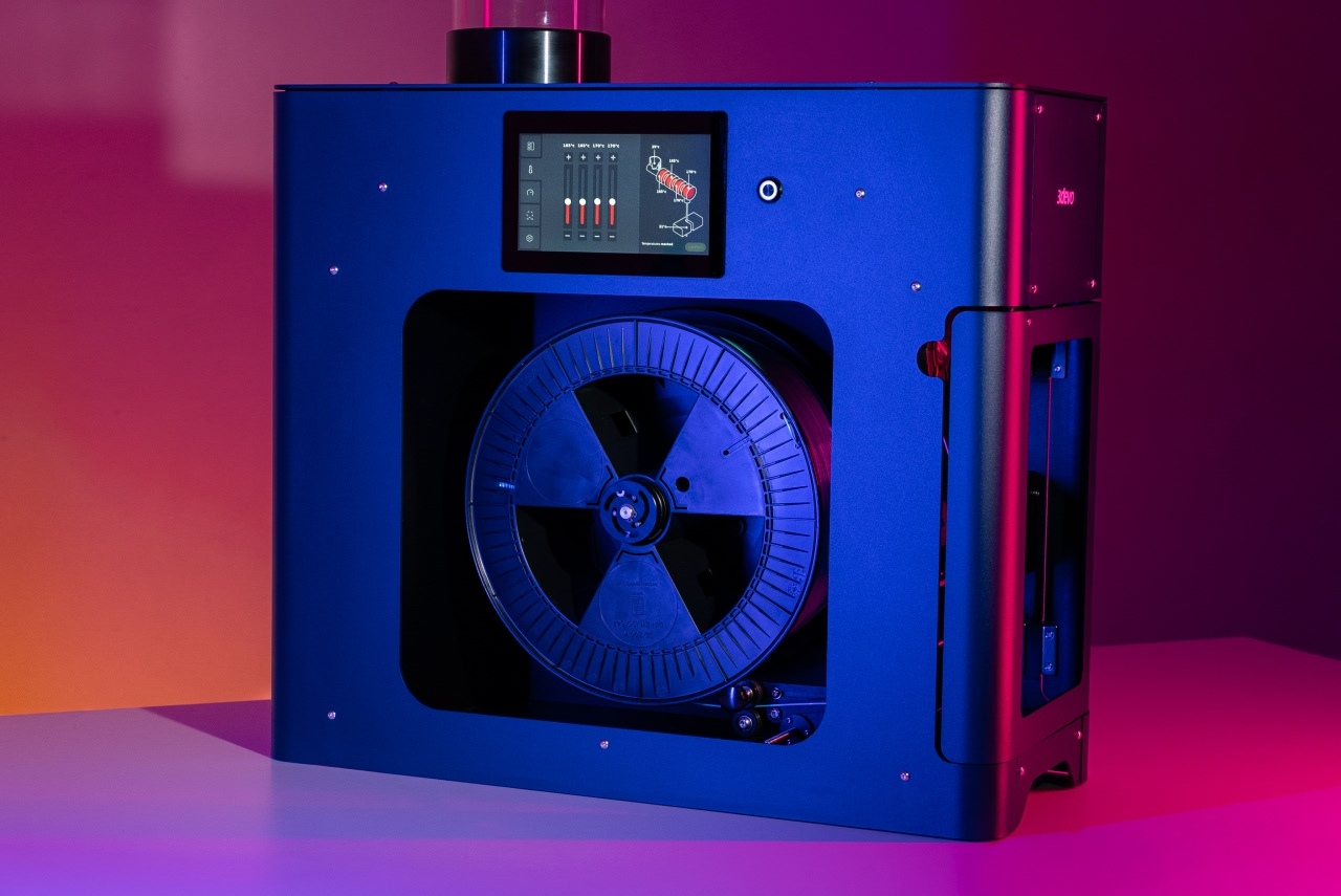 A close up of the side of the filament maker two, in a dark red background