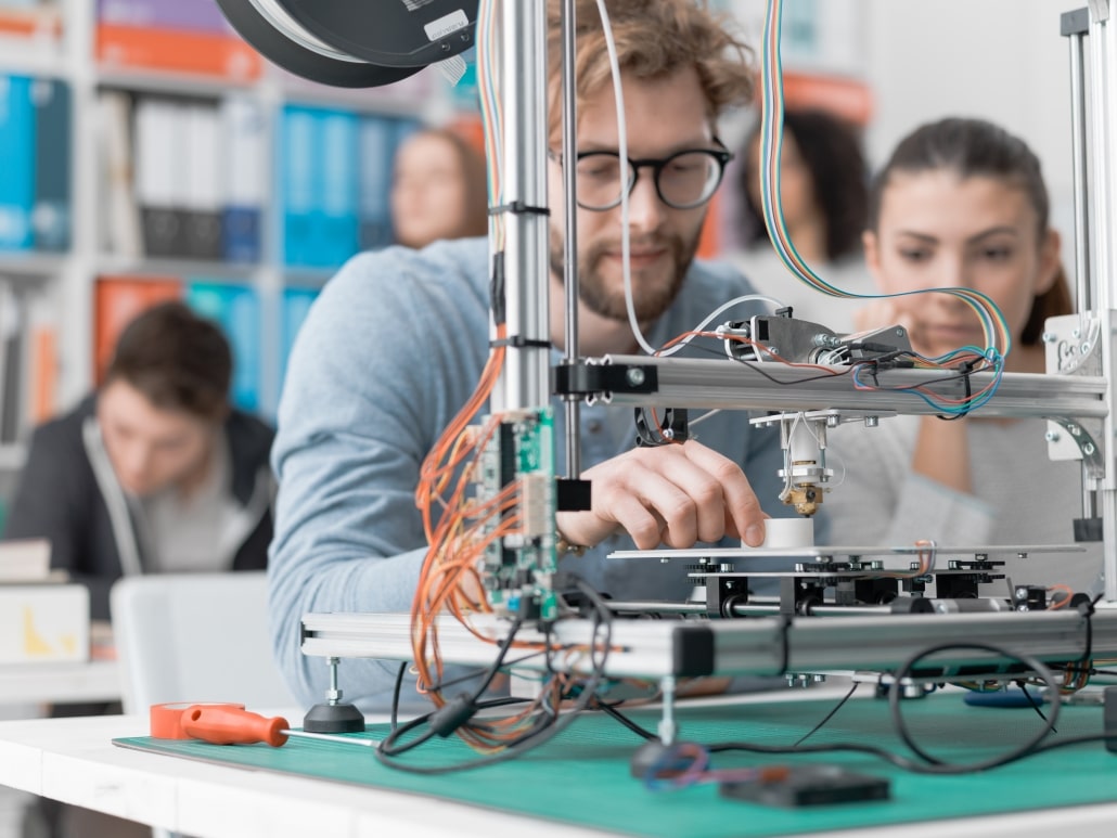 students-using-a-3d-printer-PJKMSXD-1030x773