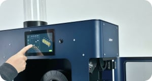 A person's hand configuring the settings in the Filament Maker TWO's touchscreen.